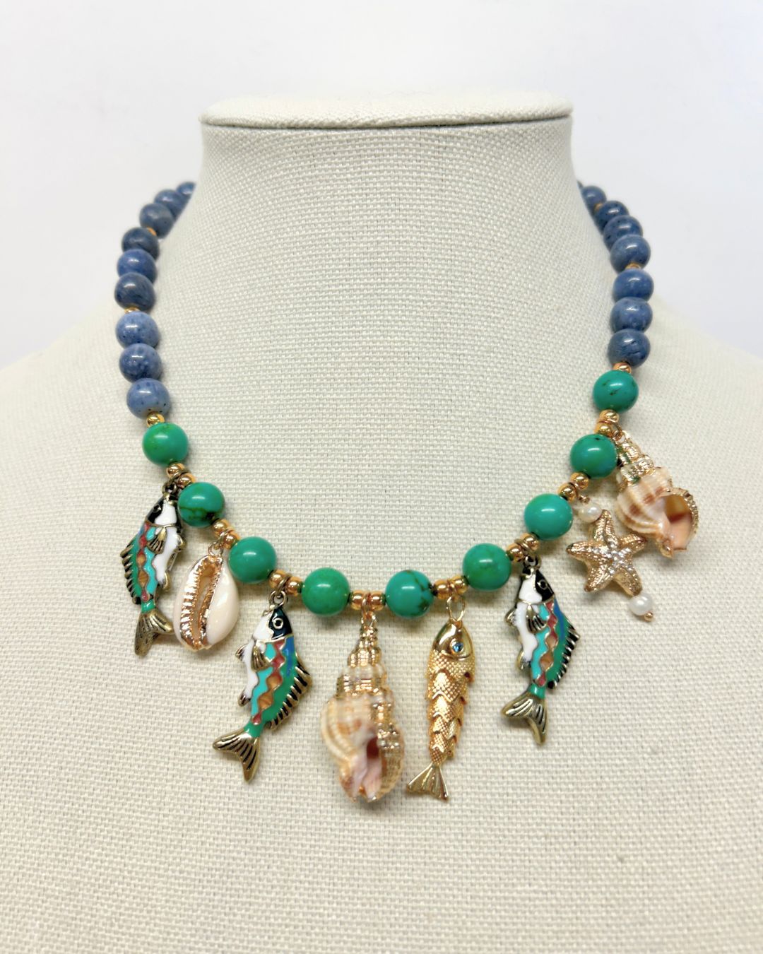 Blue sponge coral and turquoise statement necklace with sea charms on a linen neck form